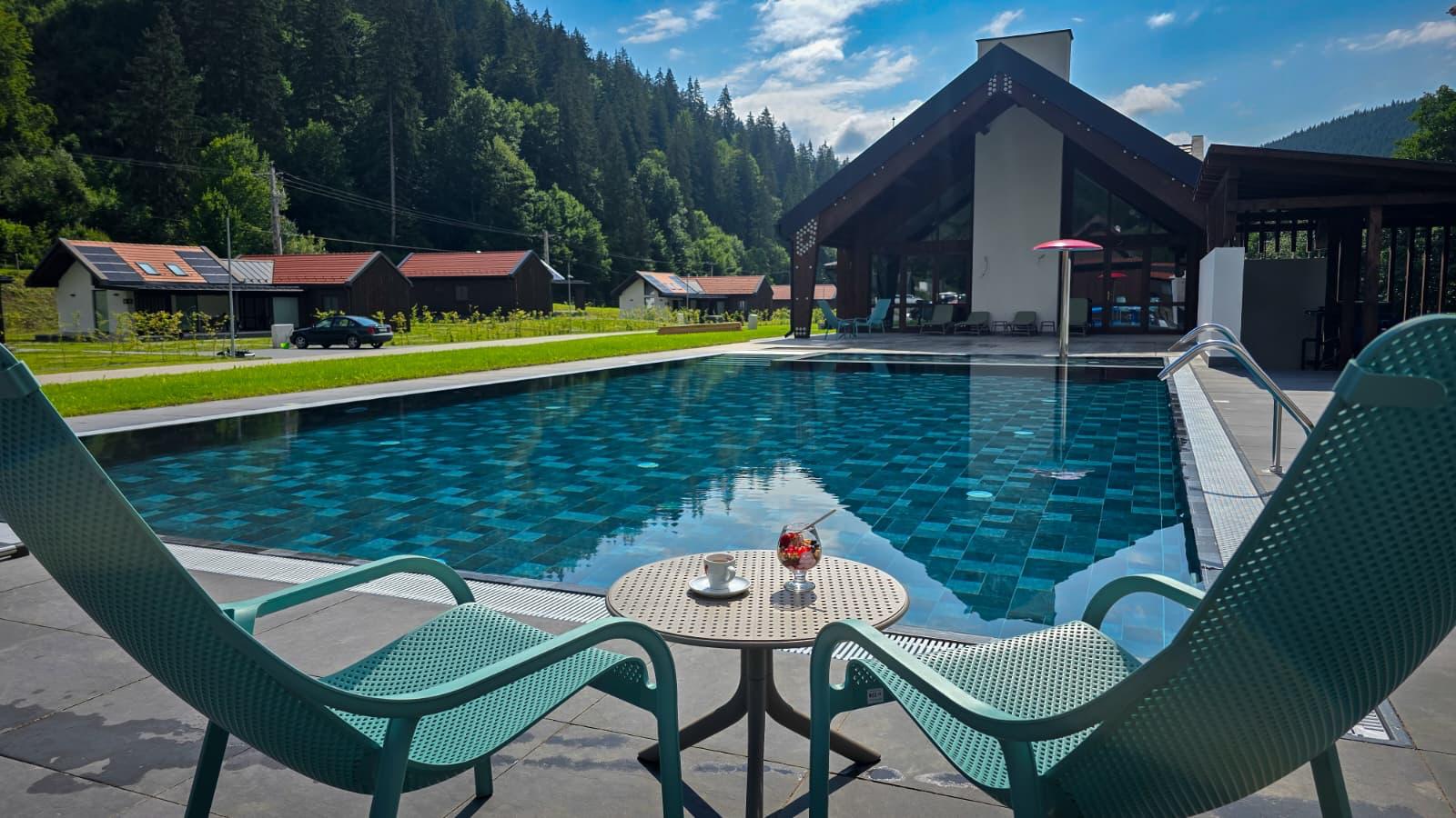 Piscina Eskaperdo Resort, cu scaune și masă pe terasă