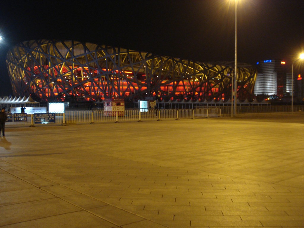 Clădire cu structură exterioară împletită, iluminată în roșu noaptea
