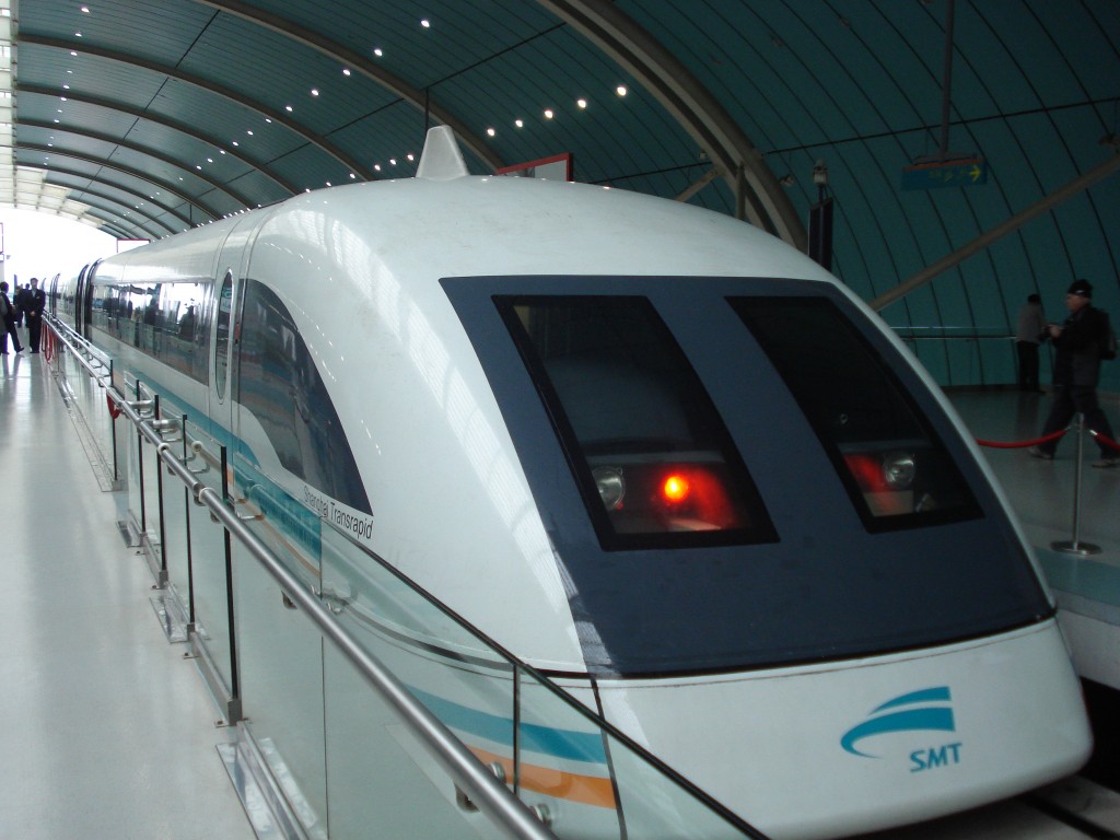 Tren alb cu bot aerodinamic oprit lângă un peron acoperit
