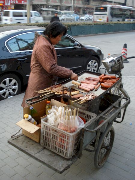 Vânzătoare lângă un cărucior încărcat cu produse și recipiente