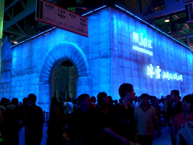 Mulțime în fața unei instalații arhitecturale luminate în albastru