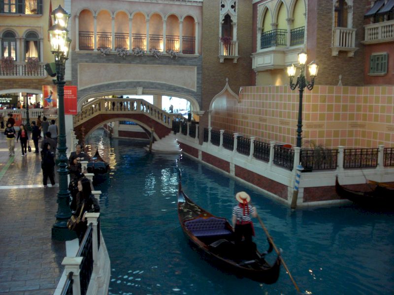 Gondolier conducând o gondolă pe lângă promenada interioară