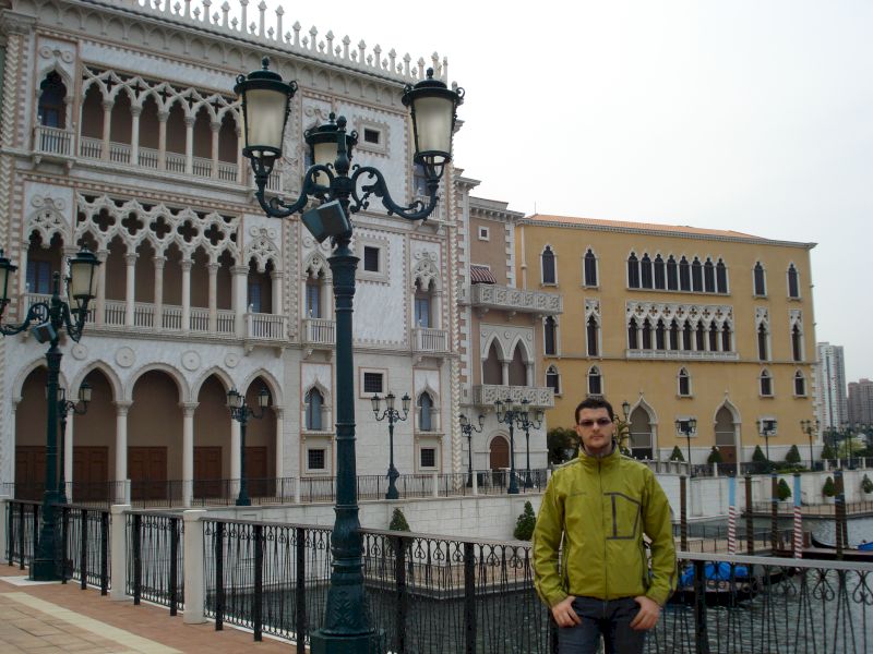 Bărbat lângă balustradă în fața unei clădiri cu arcade