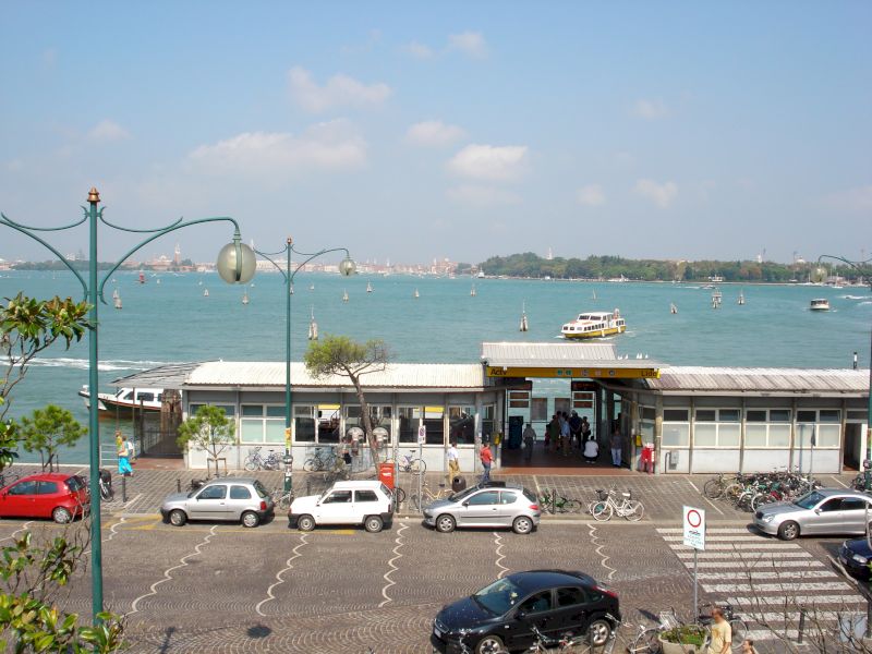 Promenadă cu felinare lângă apă și ponton acoperit