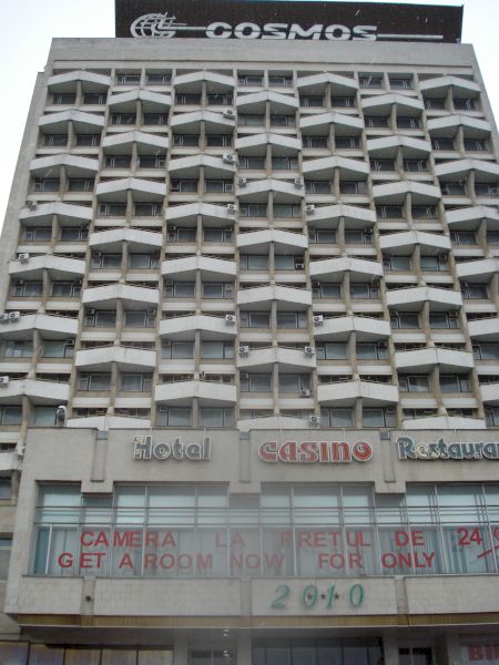 Clădire înaltă cu balcoane repetitive și inscripția Cosmos