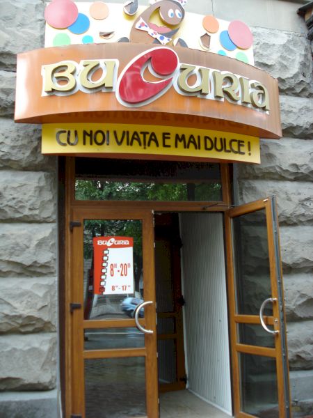Intrare de magazin cu firmă colorată și vitrină îngustă