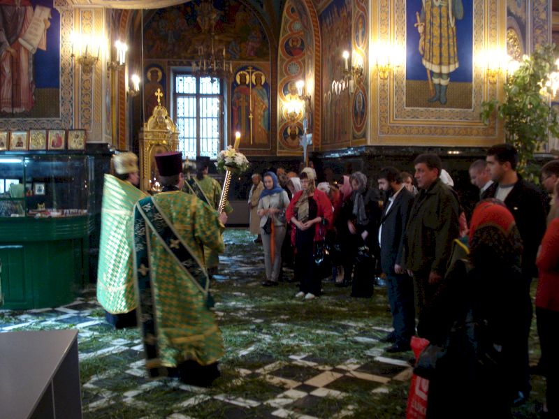 Preot în veșminte verzi în fața credincioșilor din biserică