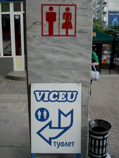 Indicator de toaletă cu săgeată pe un perete