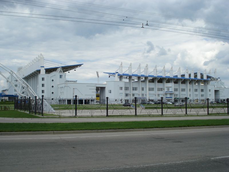 Complex alb cu acoperiș curbat dincolo de un gard