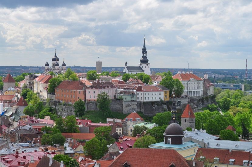 Vedere peste acoperișuri roșii spre turle și clădiri mari