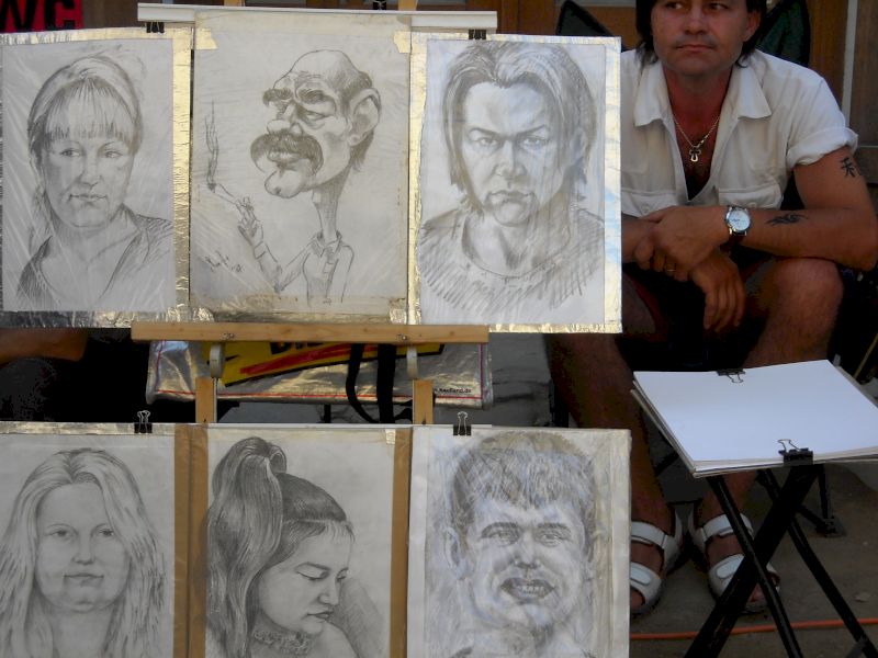 Portrete și caricaturi în creion expuse la un stand