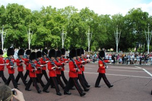 Londra Buckingham parada Militari în uniforme roșii și căciuli negre defilând pe stradă