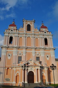 Vilnius6 Fațadă de biserică portocalie cu două turnuri și coloane