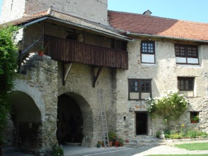 Clădire de piatră cu arcade și galerie de lemn