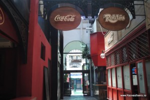 Coca Cola 1 Pasaj cu pereți roșii și firme rotunde Coca-Cola