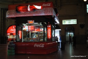 Coca Cola Buenos Chioșc roșu cu vitrine iluminate într-o hală întunecată