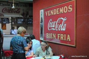 Coca Cola Montevideo Uruguay Clienți lângă un perete roșu cu reclamă Coca-Cola