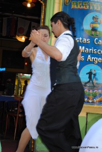 Cuplu dansând, femeia în rochie albă și bărbatul în vestă