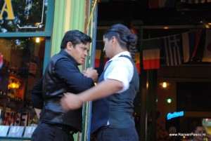 Doi bărbați dansează în fața unei intrări verzi