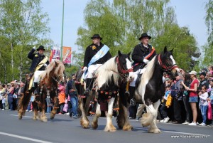 Junii Brasovului3 Călăreți cu pălării negre și eșarfe colorate în fața mulțimii