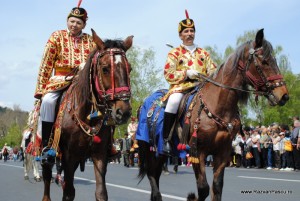 Junii Brasovului7 Doi călăreți în costume brodate și căciuli ornamentate