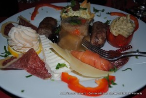 mancare romaneasca Platou cu aperitive variate, felii de mezeluri, brânzeturi și legume umplute.