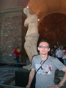 10_-_Venus_din_Milo_resize Bărbat cu ochelari lângă o statuie feminină antică fără brațe.
