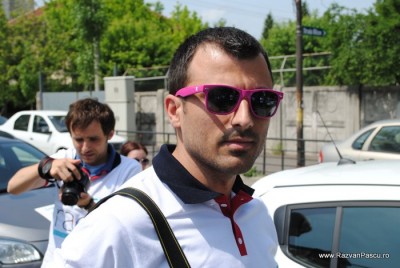 18 lover boy Bărbat cu mustață și ochelari roz, lângă mașini parcate.