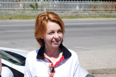 19 palariuta verde Femeie roșcată în tricou alb, fotografiată lângă șosea.