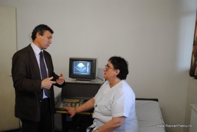 6 ecograf din 1987 Doi bărbați discută într-un cabinet, lângă un ecograf vechi.