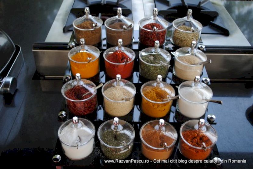 Borcane mici cu capace deschise, conținând condimente și ingrediente colorate.
