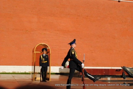 14 schimbarea garzii Militari în uniformă de ceremonie lângă zidul roșu și gheretă.