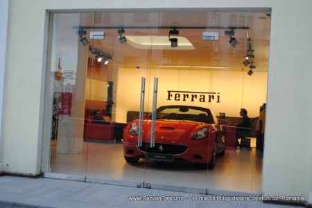 18 ferrari Automobil Ferrari roșu expus într-un showroom cu pereți galbeni.