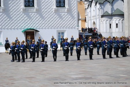 19 ceremonie Fanfară militară în uniforme albastre, aliniată în fața unei clădiri albe.