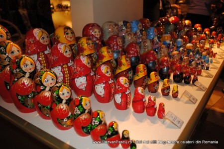 9 matrioska Păpuși matrioșka multicolore, aranjate pe rafturi în mărimi descrescătoare.