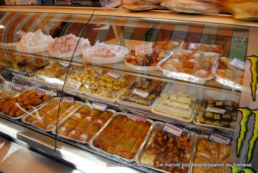 Vitrină frigorifică cu tăvi de preparate, salate și deserturi.