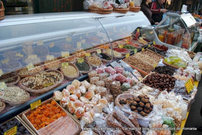 Tarabă cu fructe uscate, nuci și dulciuri în recipiente deschise.