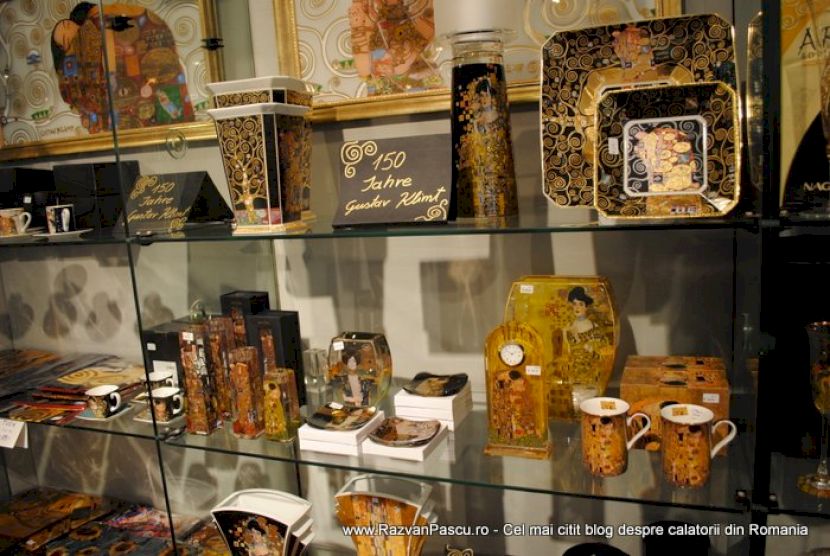 Vitrină cu tăvi, căni și obiecte decorative cu reproduceri artistice.