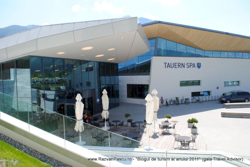 Clădire modernă Tauern SPA, cu terasă și umbrele albe.
