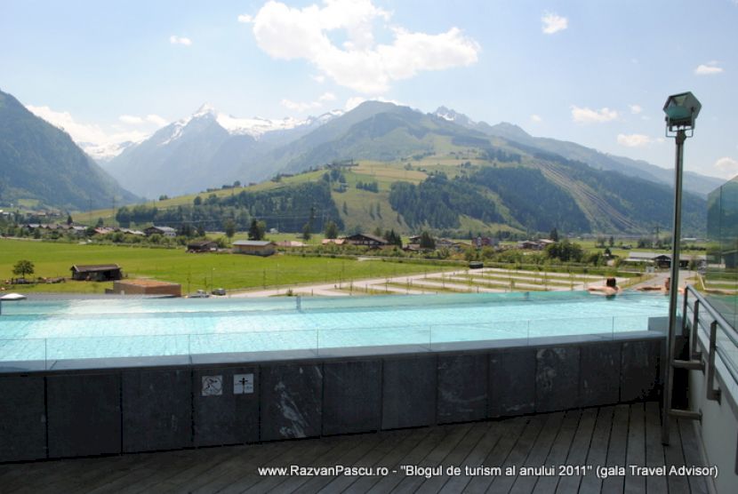 Piscină înălțată cu margine închisă, în fața unui peisaj montan.