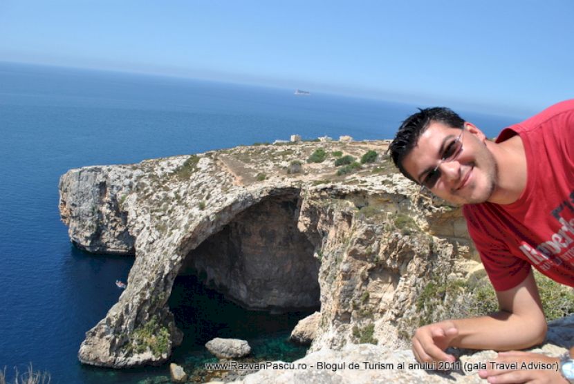 Bărbat în prim-plan lângă un arc natural de piatră