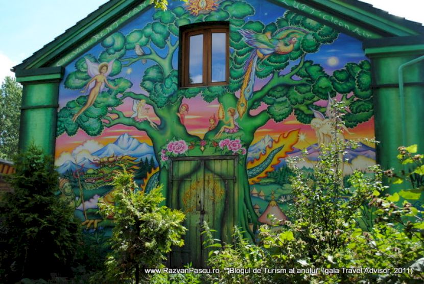 Clădire verde acoperită cu picturi murale colorate