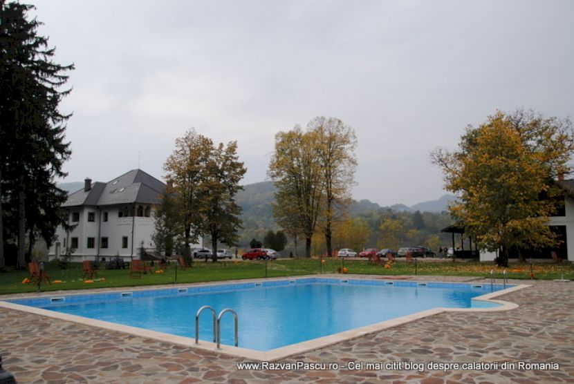 Piscină albastră lângă arbori cu frunze de toamnă