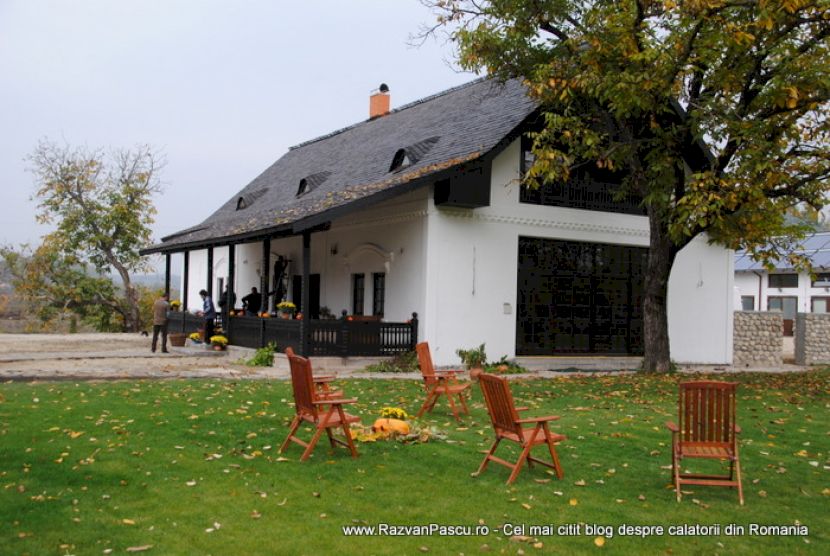 Clădire albă lângă o peluză cu mobilier de grădină