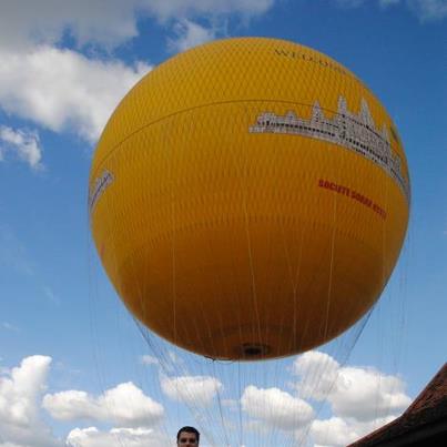 Balon galben mare văzut de jos pe cerul cu nori.