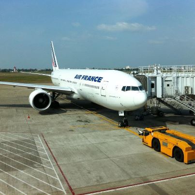 Avion Air France la poarta de îmbarcare, lângă un vehicul galben.