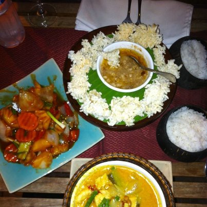 Preparate cu sos, legume și boluri cu orez pe masă.