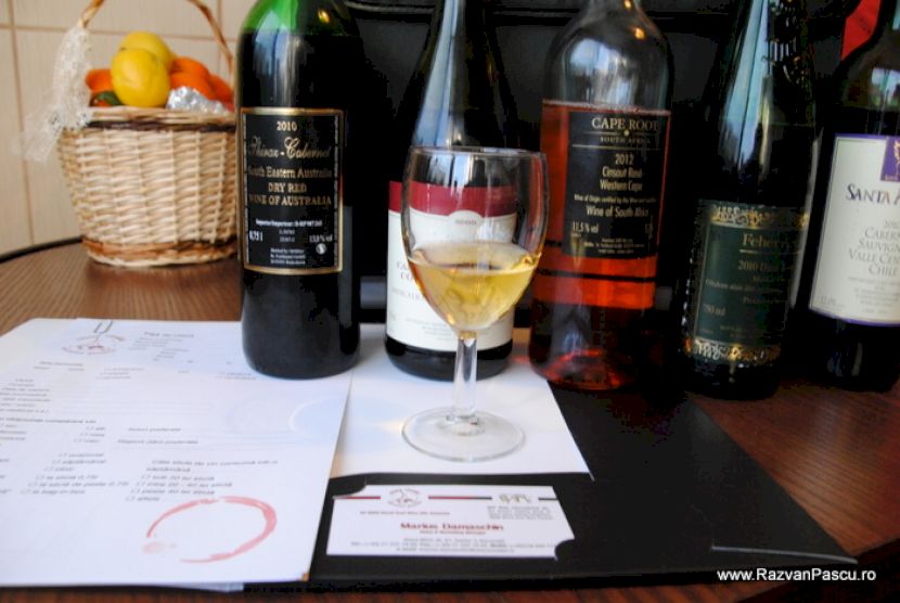 Sticle de vin și un pahar cu vin alb pe masă