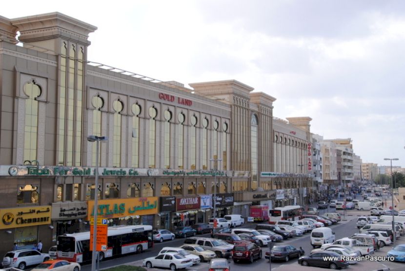 Stradă aglomerată cu magazine la parterul clădirilor