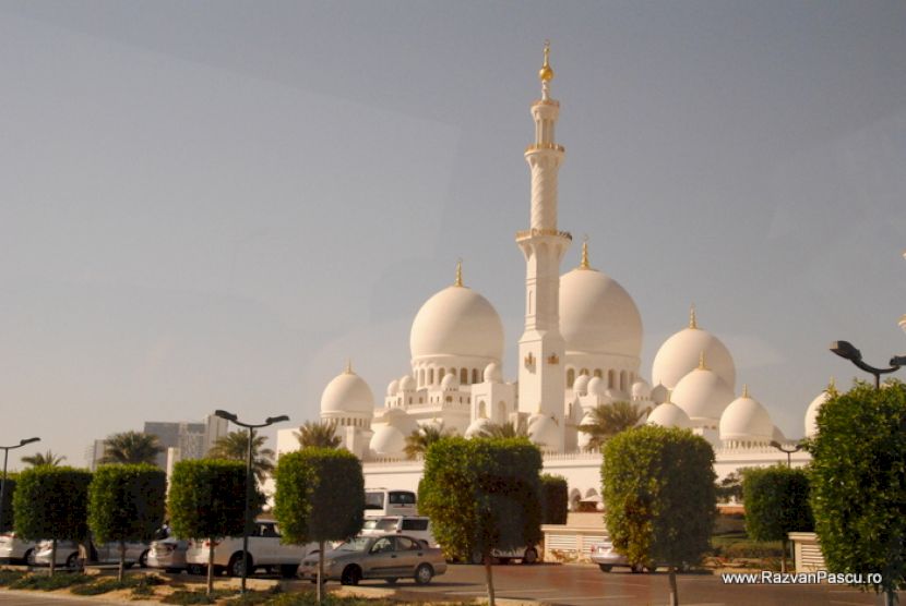 Cupole și minaret deasupra unei grădini cu arbori